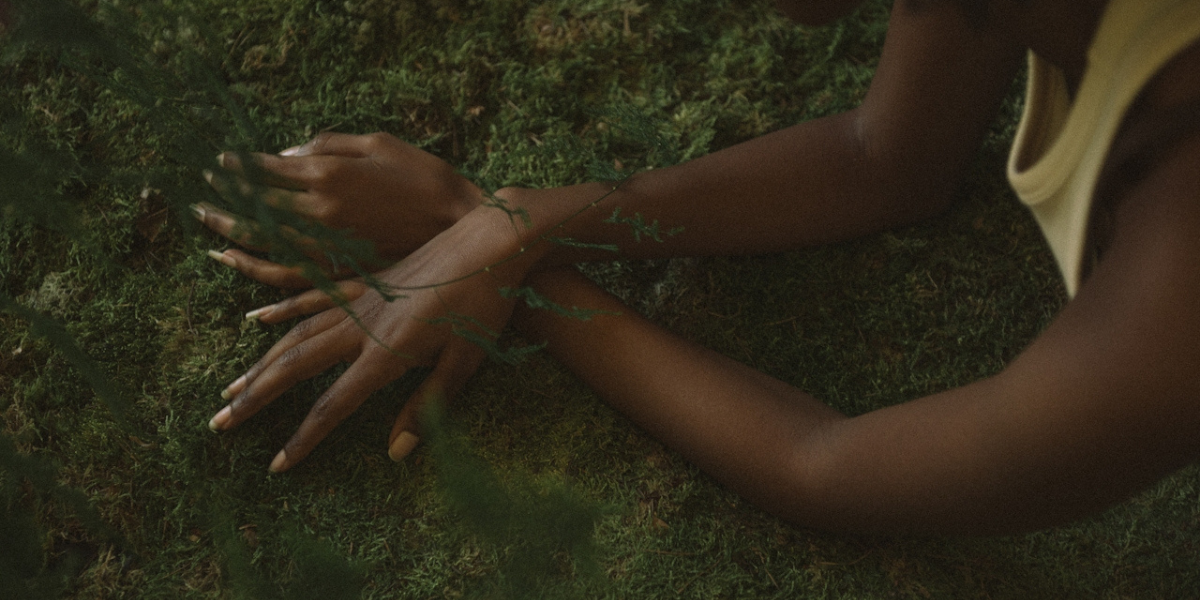 a woman laying on grass, touching it