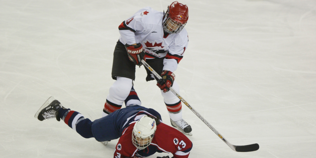 SALT LAKE CITY - FEBRUARY 21: Forward Caroline Ouellette #13 of Canada knocks down forward Julie Chu #13 of the USA as she tries to play the puck during the womens ice hockey gold medal game on February 21, 2002 at the Salt Lake City Winter Olympic at the E Center in Salt Lake City, Utah. (Photo by Robert Laberge/Getty Images)