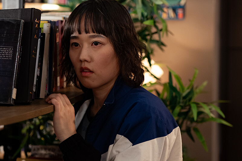 School Spirits: Quinn sneaks around a bookshelf