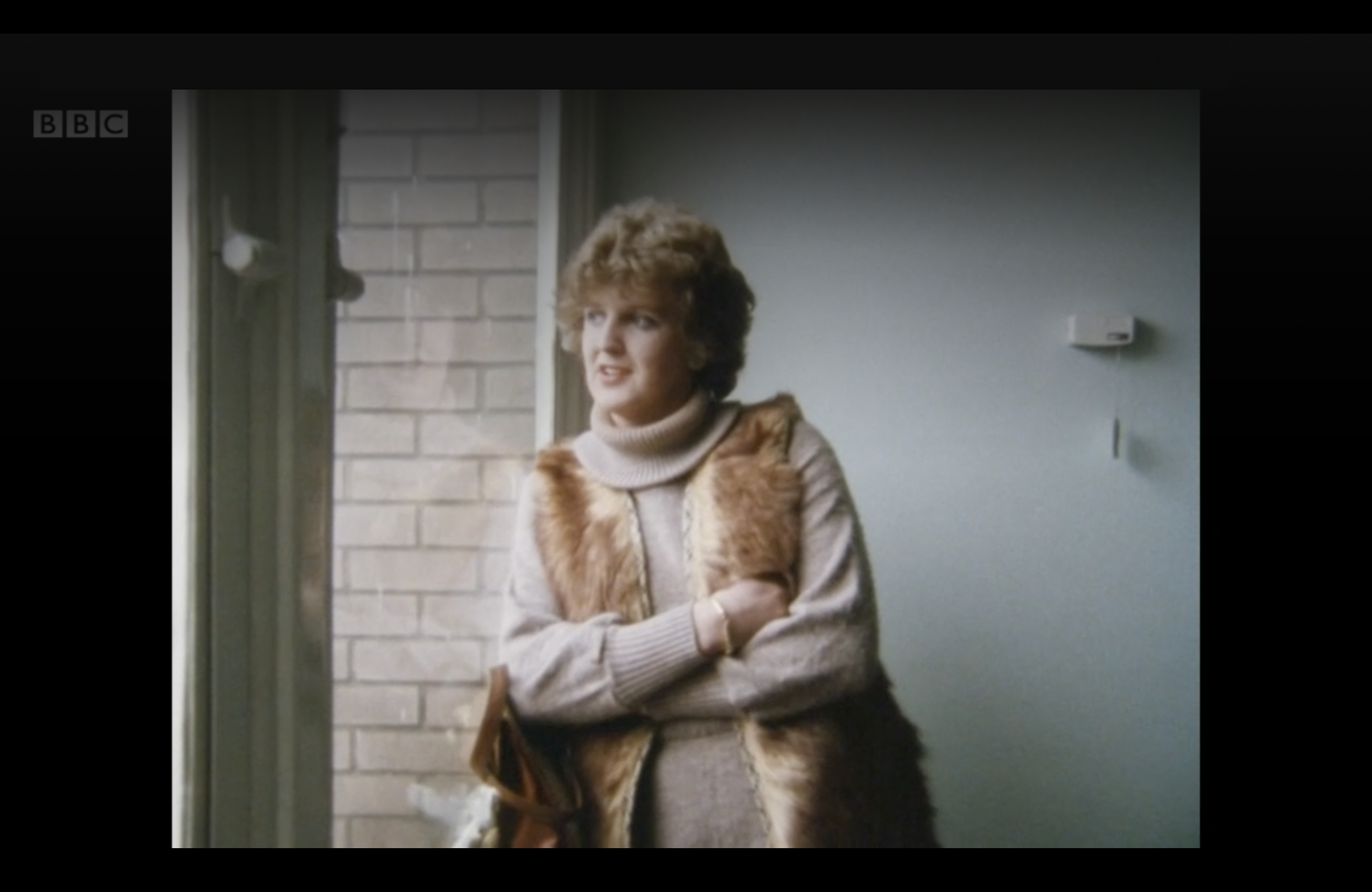 A Change of Sex documentary subject looking out the window and wearing a fabulous vest and turtleneck