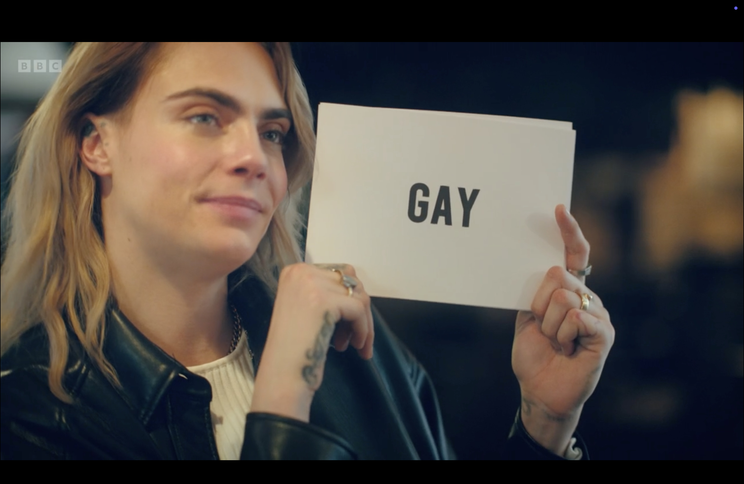 Cara Delevingne holding up the "Gay" sign
