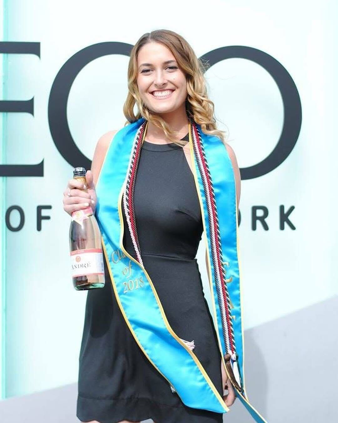 Motti at an event holding a bottle of wine