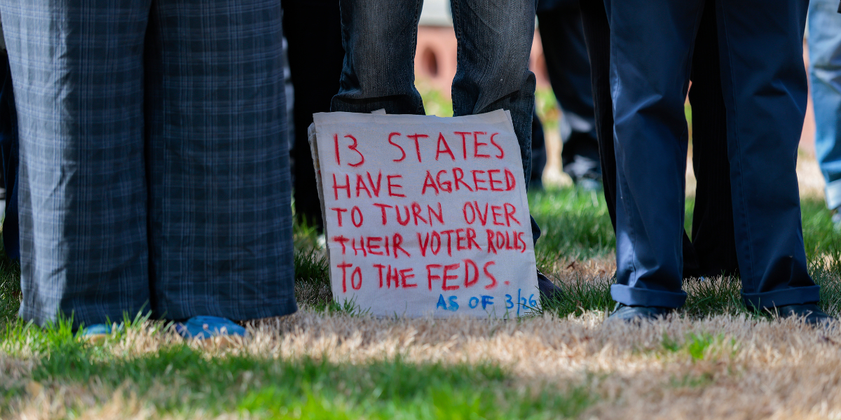 a sign that reads: 13 States Have Agreed To Turn Over Their Voter Rolls To The Feds