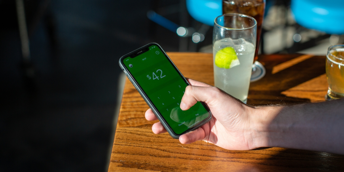 a hand using a phone to send money
