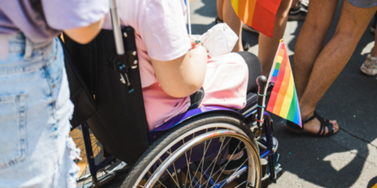 a woman in a wheelchair at a pride parade