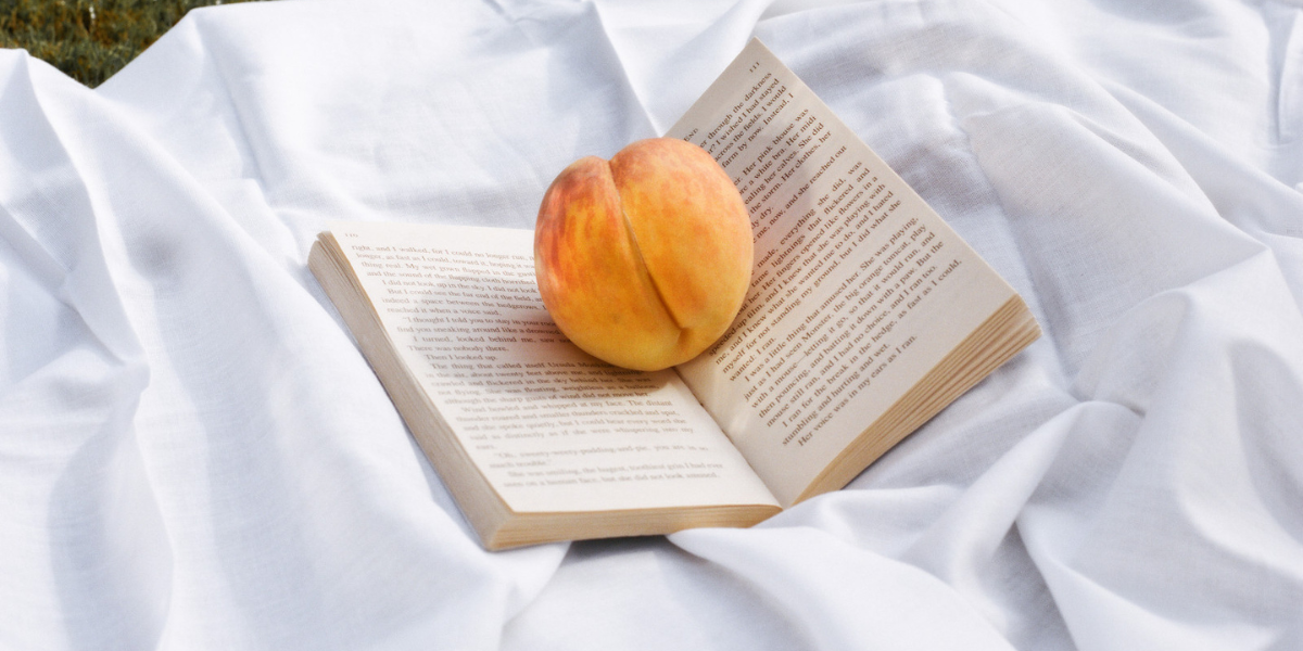 a peach sitting on top of an open book