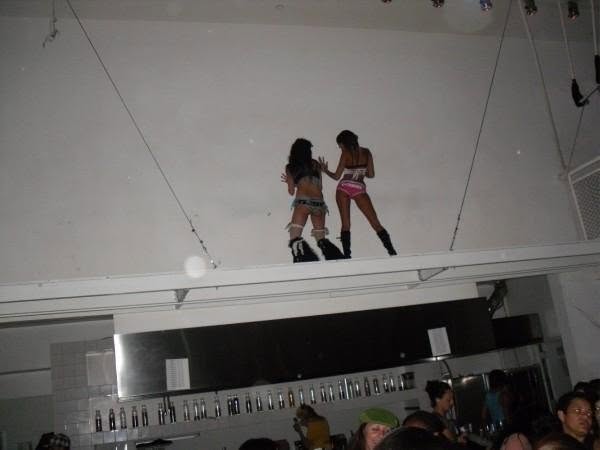 two women dancing above a bar