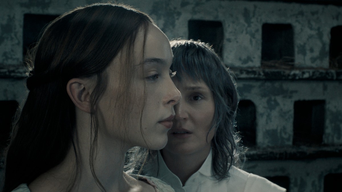 From Monster: The Lizzie Borden Story, a screenshot from the dovecote of Bridget slash Maggie facing the camera and Lizzie's side profile obscuring half of her face.