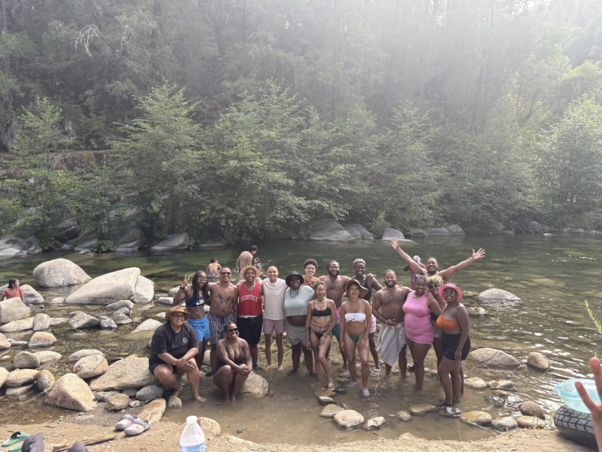 Photo of the Black Transmasc Collective + allies at the Yuba River. KB is near the middle, on the back row, with glasses on. Circa June 2026.